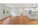 Open-concept living room with hardwood floors, a large window, and open access to the kitchen for seamless entertaining at 551 Belfast Dr, Gastonia, NC 28052
