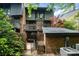 A charming brick home exterior featuring an iron gate entrance, lush landscaping, and a cozy, private patio area at 5807 Sharon Rd # A, Charlotte, NC 28210