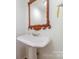 Charming pedestal sink with decorative wood-framed mirror and gold fixtures at 5807 Sharon Rd # A, Charlotte, NC 28210