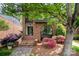Charming brick facade with unique arched window, landscaped garden, and inviting front steps leading to the main entrance at 5807 Sharon Rd # A, Charlotte, NC 28210