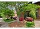Brick townhome featuring a well-maintained yard, lush landscaping, and a charming arched window at 5807 Sharon Rd # A, Charlotte, NC 28210