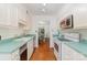 Galley kitchen with updated appliances and green countertops, with an open view to the dining room at 5807 Sharon Rd # A, Charlotte, NC 28210