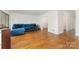 Bright living room featuring hardwood floors, white walls, and a view into the entryway at 5807 Sharon Rd # A, Charlotte, NC 28210