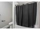 Bright bathroom with modern fixtures, a toilet, and a shower with a black shower curtain at 601 Whisnant St, Shelby, NC 28150