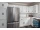 Bright kitchen featuring white cabinets, a subway tile backsplash, stainless steel refrigerator, and marble countertops at 601 Whisnant St, Shelby, NC 28150