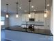 Bright kitchen showcasing a spacious island with black countertops, white cabinets, and modern pendant lights at 6333 Honor Ave, Midland, NC 28107