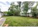 Spacious backyard with lush green lawn bordered by a wooden fence and mature trees at 8210 Lantana Dr, Denver, NC 28037