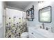 Bright bathroom with a modern vanity, updated fixtures, and a decorative floral shower curtain at 8210 Lantana Dr, Denver, NC 28037