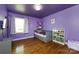 Purple themed bedroom featuring a gray daybed, hardwood floors, and natural light from a window at 8210 Lantana Dr, Denver, NC 28037