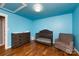 Charming Bedroom with a crib, dresser, hardwood floors, and bright blue walls and ceiling at 8210 Lantana Dr, Denver, NC 28037