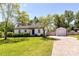 Charming home with blue door, lush green lawn, a detached garage, and mature trees at 8210 Lantana Dr, Denver, NC 28037