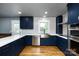 Bright kitchen featuring custom blue cabinets, stainless steel appliances, and hardwood floors at 8210 Lantana Dr, Denver, NC 28037