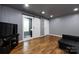 Bright living room with hardwood flooring, modern lighting, a sliding barn door, and minimalist decor at 8210 Lantana Dr, Denver, NC 28037