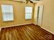 A bedroom with hardwood floors, two windows, and neutral walls at 8608 Warwick Crest Ln, Charlotte, NC 28215