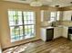 Bright kitchen featuring white cabinets, stainless steel appliances, and a large window for natural light at 8608 Warwick Crest Ln, Charlotte, NC 28215