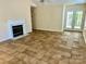 Bright living room with tile floors, a cozy fireplace, and access to a patio through glass doors at 8608 Warwick Crest Ln, Charlotte, NC 28215