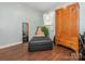 Bedroom boasting an armoire, and black leather ottoman with hardwood floors at 905 Mount Olivet Rd, Kannapolis, NC 28083