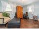 Bedroom showcasing hardwood floors, bright windows, an armoire and an electric wheelchair at 905 Mount Olivet Rd, Kannapolis, NC 28083