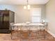 Bright dining room with modern table and chairs, black refrigerator, light fixture, and wood floors at 905 Mount Olivet Rd, Kannapolis, NC 28083