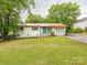 Charming one-story home with red roof, painted brick, blue door, and well-maintained lawn at 905 Mount Olivet Rd, Kannapolis, NC 28083