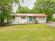 Charming single-story home with a red roof, white brick, a well-maintained lawn, and a blue front door at 905 Mount Olivet Rd, Kannapolis, NC 28083