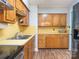 Functional kitchen with wooden cabinets, laminate countertops, double sink, and vinyl flooring at 905 Mount Olivet Rd, Kannapolis, NC 28083