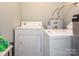 Laundry room area features a standard white washer and dryer with a water heater behind it at 905 Mount Olivet Rd, Kannapolis, NC 28083