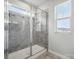 Modern glass-enclosed shower with a tiled surround and natural light streaming through the window at 9424 Avery Lilac Ln # 83, Fort Mill, SC 29707