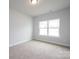 Bedroom with a window that offers plenty of natural light and neutral carpet at 1030 Gardenia Dr # 2, Mt Ulla, NC 28125