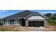 New construction exterior features a two-car garage with a stone facade and gray siding accents at 1030 Gardenia Dr # 2, Mt Ulla, NC 28125