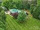 An aerial view of a beautiful log home with green roof and large manicured lawn at 10583 Earnhardt Lake Rd, Davidson, NC 28036