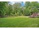 Expansive backyard features well-kept lawn and borders of trees, with deck visible at 10583 Earnhardt Lake Rd, Davidson, NC 28036
