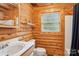 Bathroom with wooden walls and a classic white toilet and sink at 10583 Earnhardt Lake Rd, Davidson, NC 28036