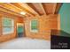 Bright log cabin bedroom with natural light and neutral carpet flooring at 10583 Earnhardt Lake Rd, Davidson, NC 28036