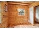 Cozy bedroom featuring wooden walls, hardwood floors, and a window with natural light at 10583 Earnhardt Lake Rd, Davidson, NC 28036