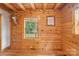 Unfurnished bedroom in a log cabin with wood walls and flooring at 10583 Earnhardt Lake Rd, Davidson, NC 28036