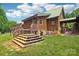 Log home exterior with a mix of stone and log siding, wooden stairs leading to the backyard at 10583 Earnhardt Lake Rd, Davidson, NC 28036