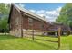 Exterior view of the house showing the stone foundation, log siding, and a well-maintained lawn at 10583 Earnhardt Lake Rd, Davidson, NC 28036