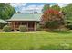 Inviting log home with a green roof, a cozy front porch, and well-manicured landscaping at 10583 Earnhardt Lake Rd, Davidson, NC 28036