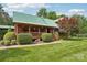 Charming log cabin with a well-manicured front yard, mature trees, and a covered porch at 10583 Earnhardt Lake Rd, Davidson, NC 28036