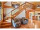 Cozy log cabin living area with wood staircase and view into the kitchen at 10583 Earnhardt Lake Rd, Davidson, NC 28036