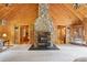 Open living room featuring a soaring stone fireplace and natural wood walls and ceiling at 10583 Earnhardt Lake Rd, Davidson, NC 28036