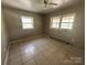 Bedroom with tile floors, a ceiling fan, and two large windows at 10625 Cool Springs Rd, Woodleaf, NC 27054