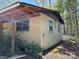 The building exterior features an unfinished covered porch, stucco, and green trim windows at 10625 Cool Springs Rd, Woodleaf, NC 27054