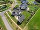 Aerial view of house showcasing the pool, patio, surrounding landscaping, and neighborhood at 11015 Benjamin Smith Ave, Huntersville, NC 28078