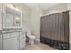 This bathroom includes a brushed nickel faucet, dark shower curtain, and toilet at 11015 Benjamin Smith Ave, Huntersville, NC 28078