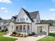 Stunning white two-story home with black roof, inviting front porch, and manicured lawn at 11015 Benjamin Smith Ave, Huntersville, NC 28078