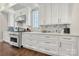 Modern kitchen with white cabinets, stainless steel appliances, and hardwood floors at 11015 Benjamin Smith Ave, Huntersville, NC 28078