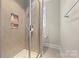 Walk-in shower features gray tiling, built-in shelving, and glass door at 11015 Benjamin Smith Ave, Huntersville, NC 28078