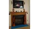 Close-up of the fireplace with decorative wooden dolphin statues and artwork at 130 Overcreek Rd, Mooresville, NC 28117